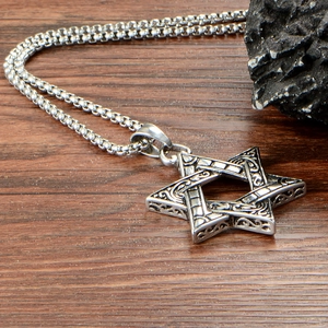 Vintage stainless steel Star of David pendant necklace on a rustic wood background
