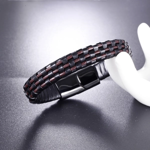 Detail of woven black and brown leather bracelet with black magnetic steel clasp