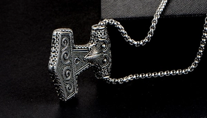 Detail of Thor's hammer Mjölnir pendant with intricate viking relief on a box chain
