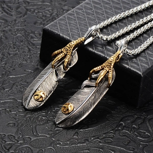 Close-up of vintage feather pendants with eagle claws on a black textured background