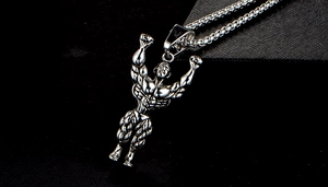 Macro detail of silver muscular bodybuilder pendant with realistic embossed texture
