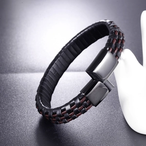 Detail of woven black and brown leather bracelet with sleek black magnetic metal clasp
