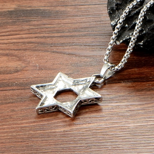 Detailed macro view of silver stainless steel hexagram pendant with vintage engraved sides