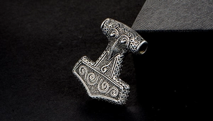 Macro shot of Thor's hammer Mjölnir pendant in vintage silver with spiral relief