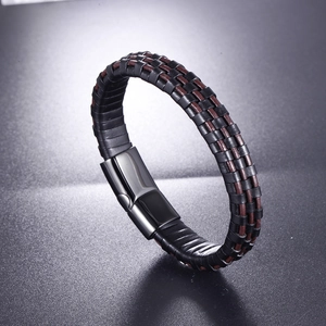 Macro detail of braided black and brown leather bracelet with magnetic metal clasp