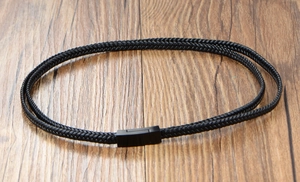 Detail of multi-layer black braided leather bracelet with a sleek magnetic metal clasp