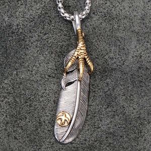 Detailed macro view of vintage feather pendant with golden eagle claw in steel