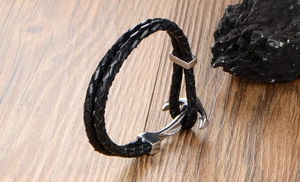Detailed close-up of double-layer black braided leather bracelet with silver anchor clasp