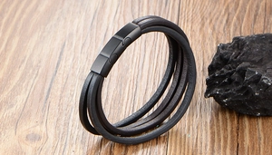 Détail d'un bracelet multicouche en cuir noir pour homme avec fermoir magnétique mat