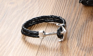 Detail of black woven leather strap with silver stainless steel anchor clasp on wood