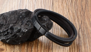 Détail d'un bracelet multicouche en cuir avec fermoir magnétique en métal noir mat