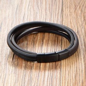 Bracelet multicouche en cuir noir pour homme avec fermoir magnétique mat sur bois