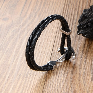 Men's double-layer black braided leather bracelet with silver metal anchor clasp on wood