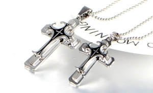 Macro detail of silver and black layered cross pendants on beaded stainless steel chains
