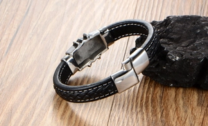 Close-up of black leather bracelet with white stitching on a rustic wooden background