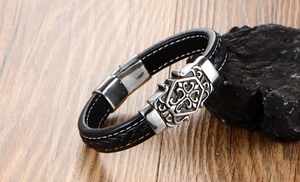 Macro shot of men's black leather braided bracelet with vintage cross buckle