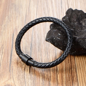 Handmade black braided leather bracelet with matte magnetic clasp on stone display