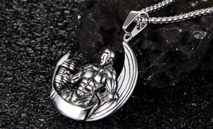 Vue macro d'un pendentif haltérophile et lune en acier argenté sur minerai noir