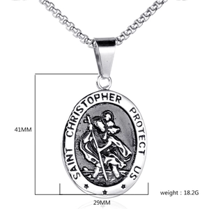 Macro detail of silver Saint Christopher oval pendant with vintage black engraving