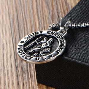 Detail of silver Saint Christopher religious medallion with engraved text and chain