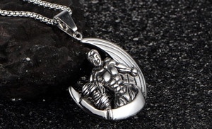 Vue macro du pendentif haltère argenté avec homme musclé et chaîne box en acier