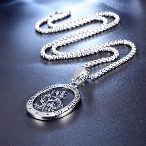 Macro detail of Saint Christopher silver pendant with embossed relief and protective text