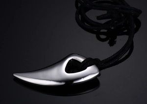 Polished silver stainless steel wolf tooth pendant necklace with a black woven cord