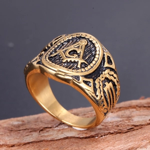 Macro shot of gold Freemason ring with G symbol on a rustic wood texture surface