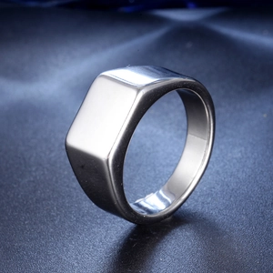 Macro shot of rectangular signet ring with polished silver finish on blue silk fabric