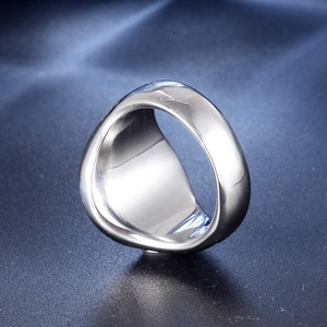 Macro shot of wide polished silver stainless steel ring on blue leather surface