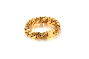 Macro view of gold curb link bracelet featuring a secure rectangular folding clasp