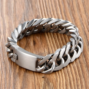 Bracelet gourmette pour homme en acier brossé avec plaque ID sur fond en bois naturel