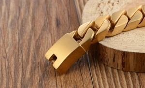 Close-up of golden stainless steel Cuban link bracelet with large square box clasp detail