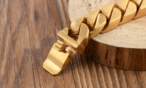Macro shot of gold Cuban chain bracelet showing polished clasp and metal link details