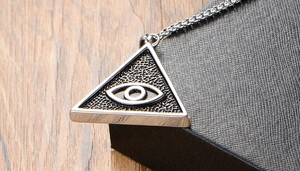 Vue macro d'un pendentif triangle en acier inoxydable avec l'Oeil de la Providence sur cuir