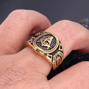 Detailopname van vintage gouden vrijmetselaarsring met G-logo en kompas gravures