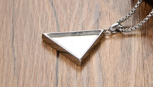 Vue latérale macro du pendentif œil triangulaire en acier inoxydable sur chaîne