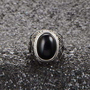 Macro detail of vintage silver steel ring with oval black stone and ornate carvings