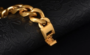 Detail of gold-plated heavy Cuban link bracelet with matte finish and fold-over clasp