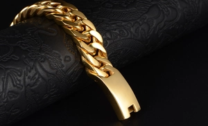 Macro shot of thick gold cuban link bracelet on embossed leather showing luxury texture
