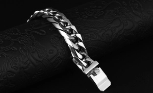 Macro shot of polished stainless steel Cuban link bracelet with textured clasp lock