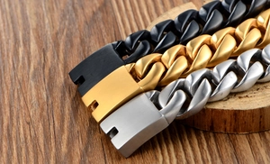 Detailaufnahme von Panzerarmbändern in Schwarz, Gold und Silber auf Holzoberfläche