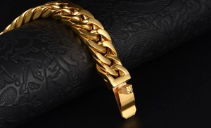 Close-up of thick gold-plated stainless steel Cuban link bracelet with textured clasp