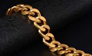 Detailed close-up of thick gold-plated Cuban link bracelet with brushed metal texture
