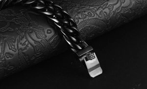Detail shot of black Cuban link bracelet with a textured fold-over safety clasp