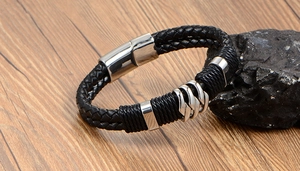 Détail d'un bracelet pour homme en cuir tressé noir avec fermoir magnétique sur roche