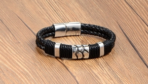 Détail d'un bracelet tressé pour homme en cuir avec des anneaux en acier inoxydable