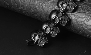 Macro detail of matte black 316L stainless steel skull charm on textured leather background