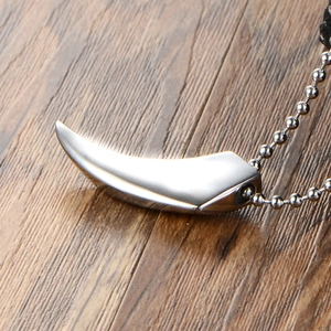 Polished stainless steel wolf tooth pendant necklace on silver ball chain with wood backdrop