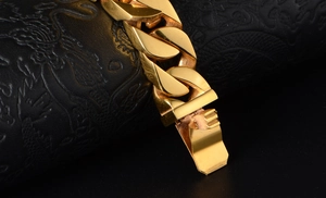 Macro shot of polished gold Cuban chain bracelet with a heavy duty clasp and metal finish